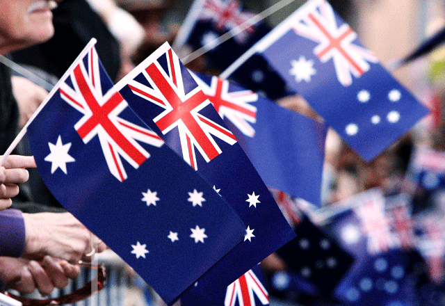 Australian flags being waved at a parade.
