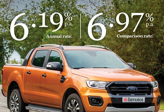 Orange four-door ute parked in a forested area