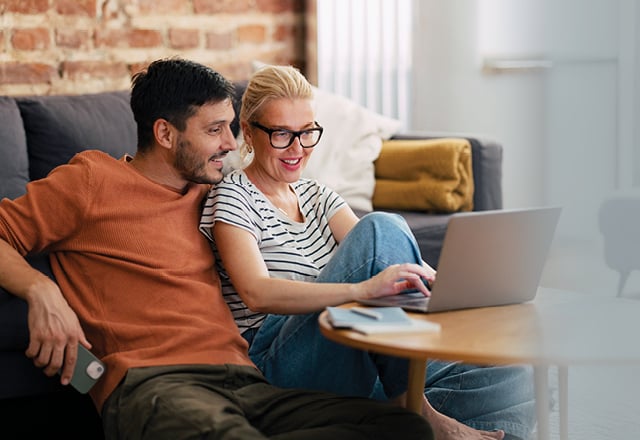 Family sitting on lawn of a suburban front yard.