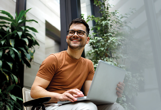 Family sitting on lawn of a suburban front yard.