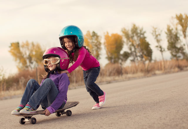 Young girls playing on a skateboard