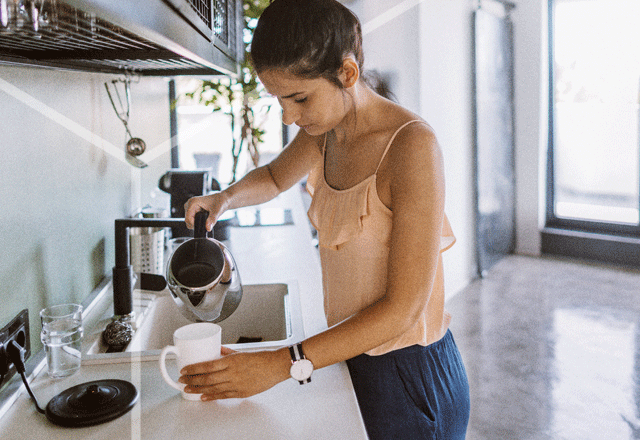 Woman making coffee in kitchen.