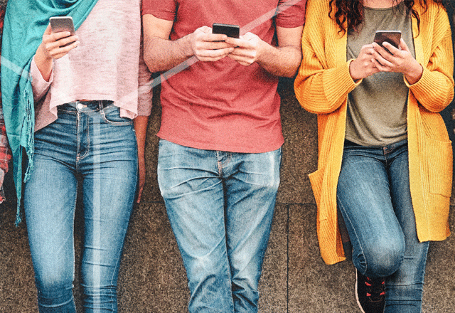 Group of people leaning against a wall.